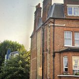 A tall Victorian red-brick building in Central London with multiple chimney stacks. Captured during a safety consultancy project assessing risks and developing method statements for chimney removal and replacement work.